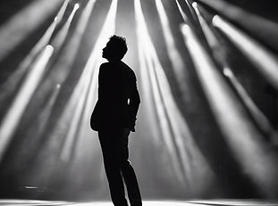 a silhouette of a man in a spotlight on a stage.jpg